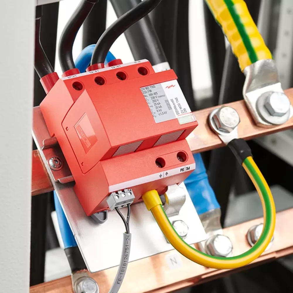 Red surge arrester, mounted and wired in a sub-distribution cabinet.