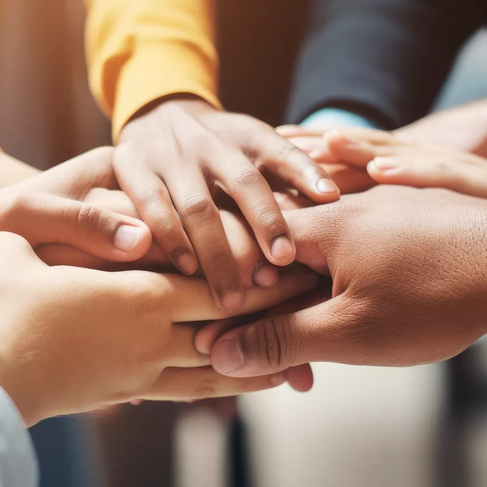 Close-up of diverse hands placed together, symbolizing shared responsibility, trust, and respect for human rights.